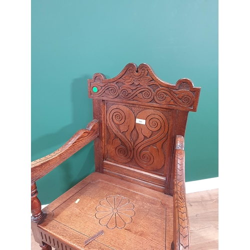 565 - A reproduction Wainscot style oak carved Armchair.