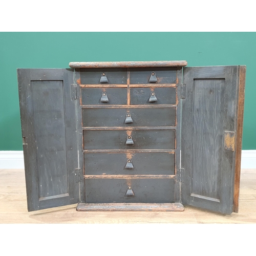 6 - A painted Cabinet with panelled doors enclosing four short and four long fitted  drawers, 1ft 10