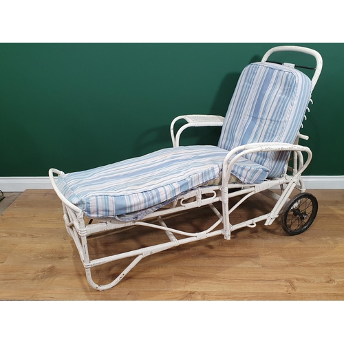 603 - A 1920's white painted wicker Sun Lounger with adjustable back rest.