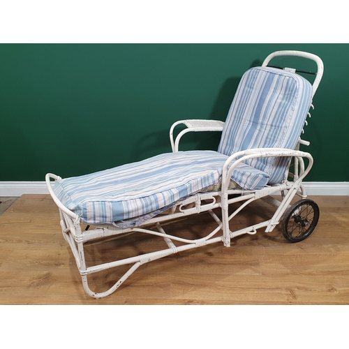 603 - A 1920's white painted wicker Sun Lounger with adjustable back rest.