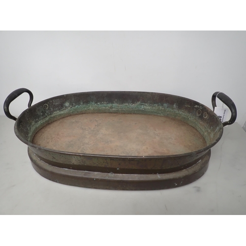 82 - An antique copper oval two-handled Pan with raised footrim, 16in