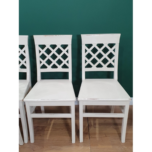 9 - A set of eight white painted Dining Chairs with lattice backs on squared supports and stretchers