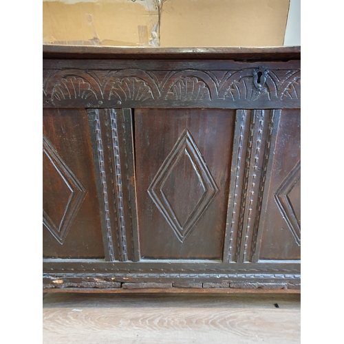 299 - A 17th Century oak Coffer with two plank lid above lozenge carved four panel front on stile supports... 