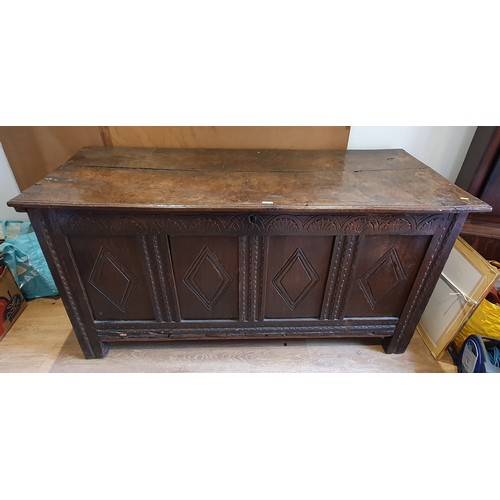 299 - A 17th Century oak Coffer with two plank lid above lozenge carved four panel front on stile supports... 