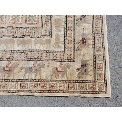 620 - A large Carpet, the border decorated figures on horseback and an inner border of animals on a beige ... 