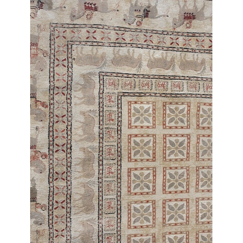 620 - A large Carpet, the border decorated figures on horseback and an inner border of animals on a beige ... 