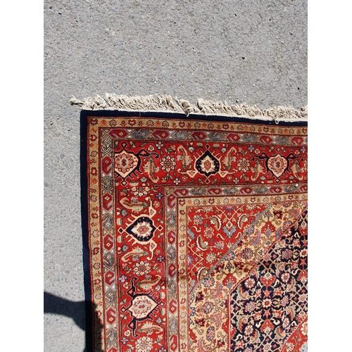 621 - A Persian style Carpet of multi-bordered design with central diamond on a red and blue ground, 9ft 9... 