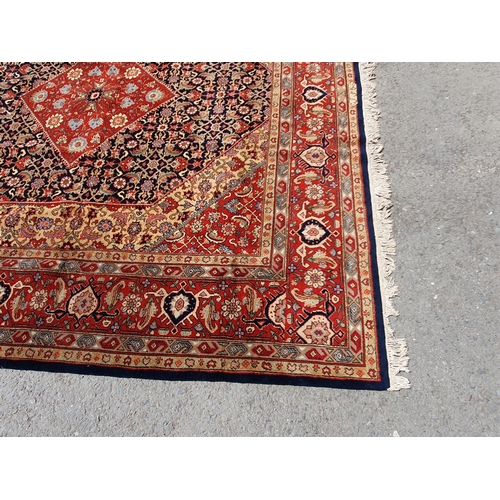 621 - A Persian style Carpet of multi-bordered design with central diamond on a red and blue ground, 9ft 9... 