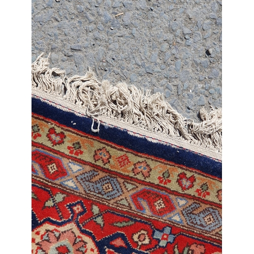 621 - A Persian style Carpet of multi-bordered design with central diamond on a red and blue ground, 9ft 9... 