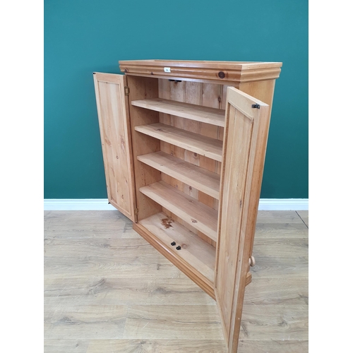 69 - A modern pine Cupboard the pair of panelled doors enclosing shelved interior, 3ft 10