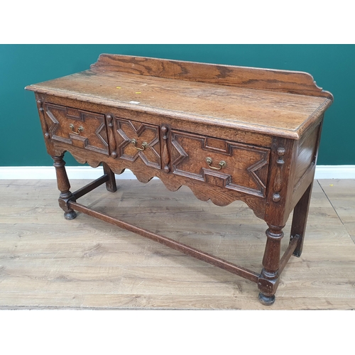 84 - An oak Sideboard with raised and shaped back, fitted three drawers with moulded decoration above sha... 