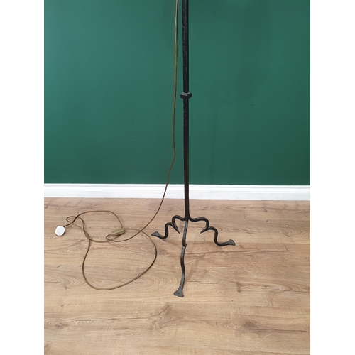 86 - A black painted cast Standard Lamp with scrolled decoration on shaped tripod supports, 6ft 2