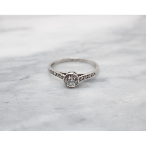 155 - An early 20th Century Diamond Ring rubover-set old-cut stone between smaller stones pavé-set to shou... 