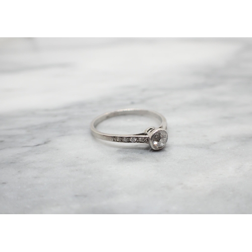 155 - An early 20th Century Diamond Ring rubover-set old-cut stone between smaller stones pavé-set to shou... 