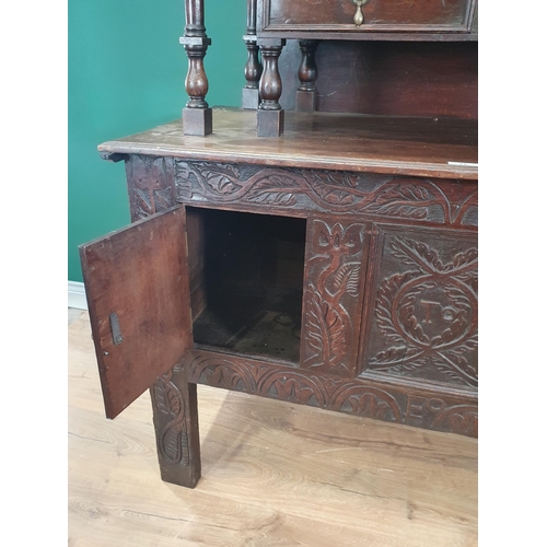 24 - A carved oak Coffer converted into Cupboard, the top section with fall front above pair of fitted dr... 