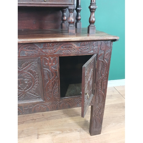 24 - A carved oak Coffer converted into Cupboard, the top section with fall front above pair of fitted dr... 