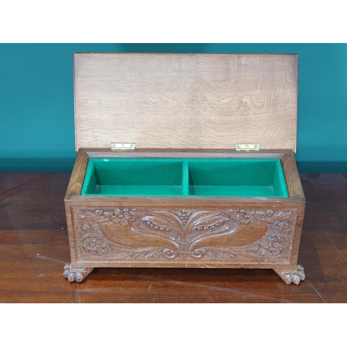 29 - A carved oak Casket with hinged lid enclosing two division lift out tray, with floral and leafage de... 