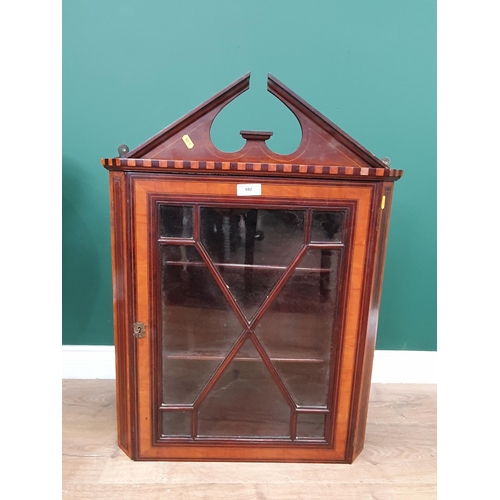 592 - A satinwood and crossbanded Hanging Corner Cupboard with shaped pediment above single astragal glaze... 