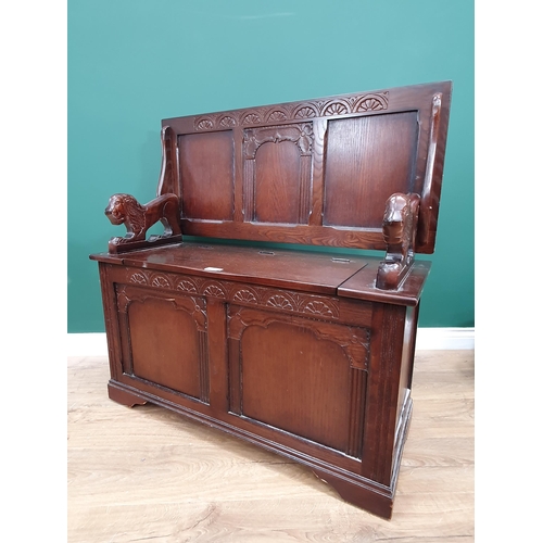 611 - A reproduction oak Monks Bench with lion supports and box seat, 2ft 5