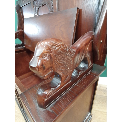 611 - A reproduction oak Monks Bench with lion supports and box seat, 2ft 5