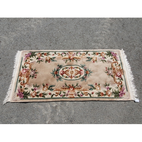 616 - A small Chinese Rug with design of flowers in various colours on a beige ground, 6ft 5in x 3ft