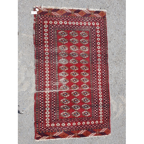 619 - A small Persian Rug, the centre with rose of medallions on a red ground, worn, 5ft 4in x 3ft 1in