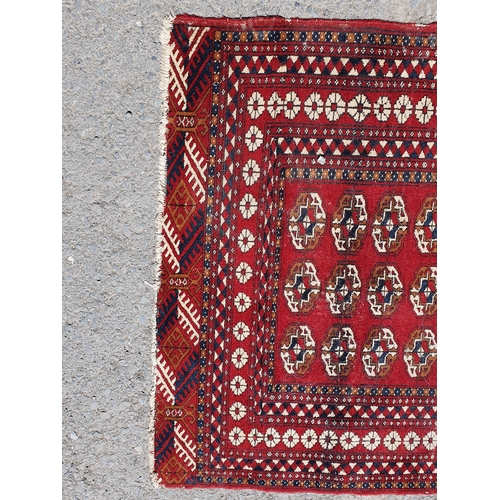 619 - A small Persian Rug, the centre with rose of medallions on a red ground, worn, 5ft 4in x 3ft 1in