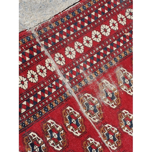 619 - A small Persian Rug, the centre with rose of medallions on a red ground, worn, 5ft 4in x 3ft 1in