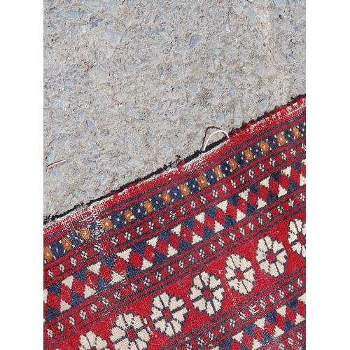 619 - A small Persian Rug, the centre with rose of medallions on a red ground, worn, 5ft 4in x 3ft 1in