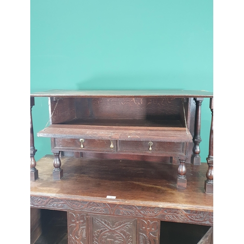 69 - A carved oak Coffer converted into Cupboard, the top section with fall front above pair of fitted dr... 