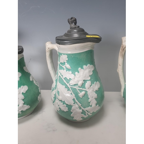 378 - A trio of green pottery Jugs with pewter lids decorated with oak leaves, and two Wedgewood style blu... 