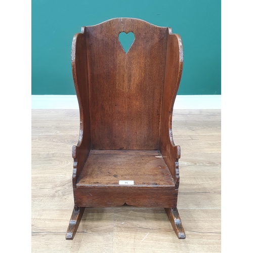 15 - An antique oak Childs Rocking Chair with pierced heart decoration.