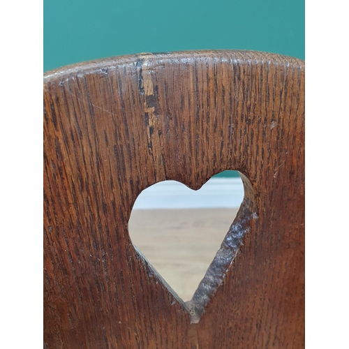 15 - An antique oak Childs Rocking Chair with pierced heart decoration.