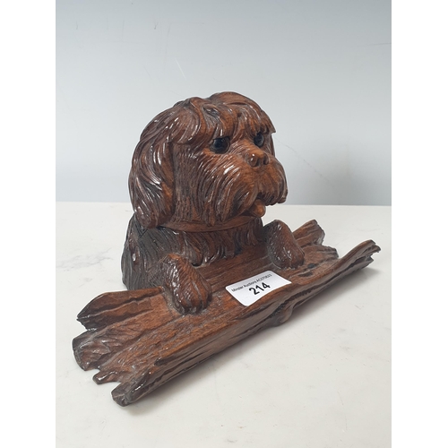 214 - A Black Forest Inkstand in the form of a dog with its paws on a log, the head hinging back to reveal... 