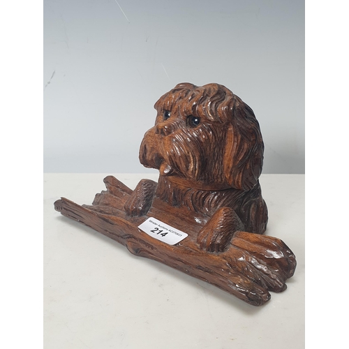 214 - A Black Forest Inkstand in the form of a dog with its paws on a log, the head hinging back to reveal... 