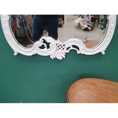 294 - A Kidney shaped two tier Occasional Table on tapered supports and a modern white painted Wall Mirror... 