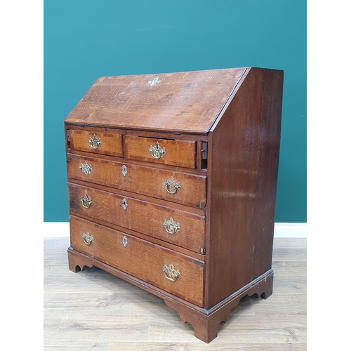 35 - An antique oak Bureau, the fall front with fitted interior above two short, three long drawers on br... 