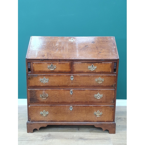 35 - An antique oak Bureau, the fall front with fitted interior above two short, three long drawers on br... 