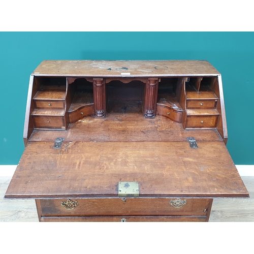 35 - An antique oak Bureau, the fall front with fitted interior above two short, three long drawers on br... 