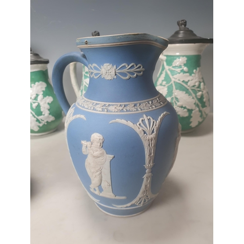 378 - A trio of green pottery Jugs with pewter lids decorated with oak leaves, and two Wedgewood style blu... 