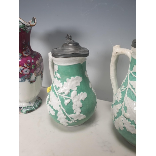 378 - A trio of green pottery Jugs with pewter lids decorated with oak leaves, and two Wedgewood style blu... 