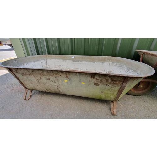 502 - A galvanised Tin Bath, 4ft 11in, and a Wheelbarrow