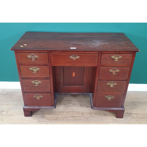 56 - A mahogany and crossbanded Kneehole Desk fitted nine drawers and single cupboard door on bracket fee... 