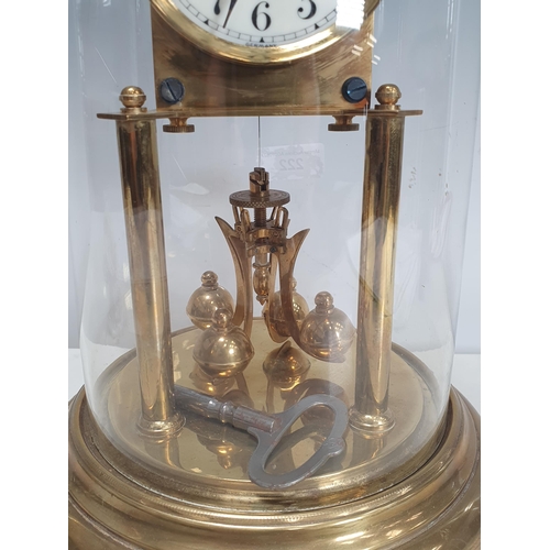 222 - A brass perpetual Clock with enamel dial under glass dome, 12in H