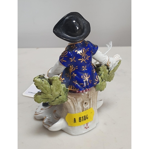 227 - A Sampson Paris style bocage Seated Figure wearing a hat, blue and gilt decorated jacket and waistco... 