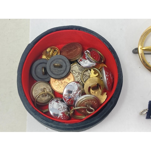 1116 - A box of Military and Police Cap Badges, Buttons and other Badges including 1899 Queen's Prize Posit... 