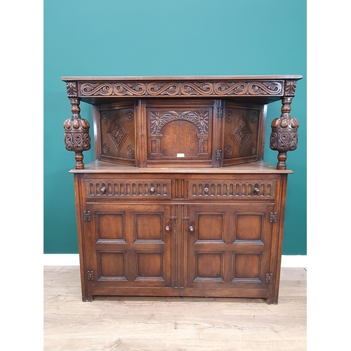 34 - A reproduction oak Court Cupboard with central cupboard flanked by turned columns, above pair of fit... 