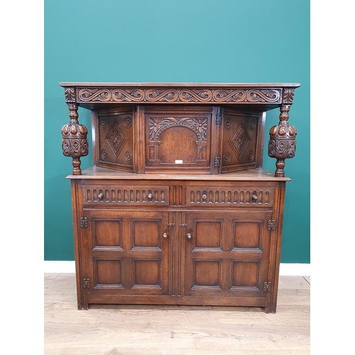 34 - A reproduction oak Court Cupboard with central cupboard flanked by turned columns, above pair of fit... 