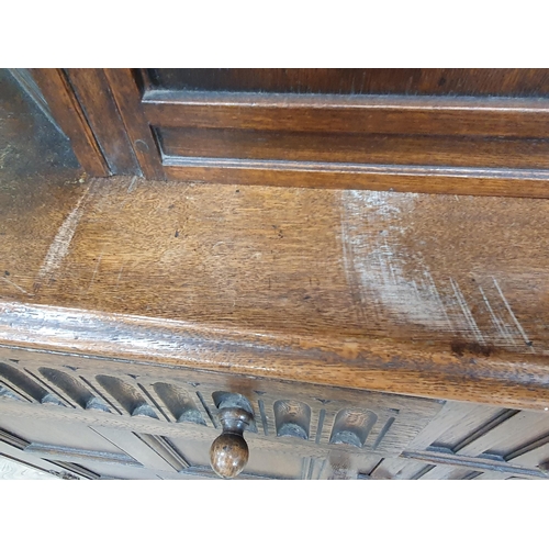 34 - A reproduction oak Court Cupboard with central cupboard flanked by turned columns, above pair of fit... 