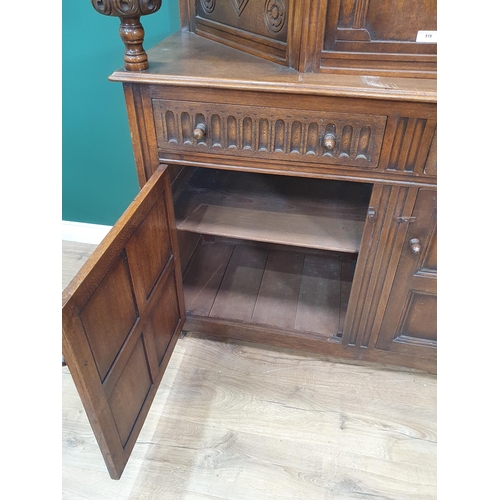 34 - A reproduction oak Court Cupboard with central cupboard flanked by turned columns, above pair of fit... 